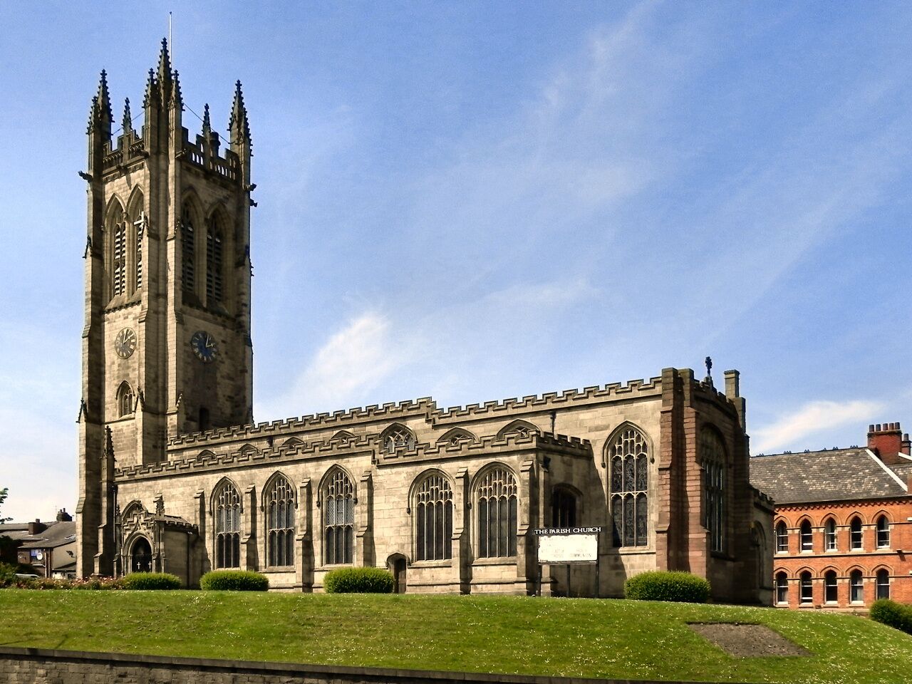 A historic church with a tall clock tower and arched windows.
