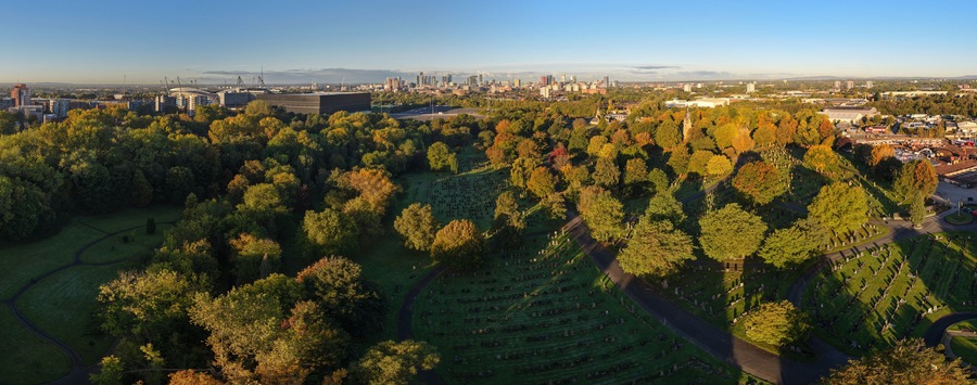 Vista urbana que incluye un gran parque con un cementerio y edificios circundantes.
