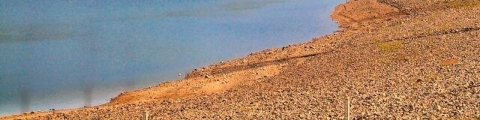 Walkerwood Reservoir Almost empty at this time of year. This reservoir actually impinges upon 4 grid squares. However the picture was taken from the road over the dam wall, standing firmly at SJ985989, and showing the arid foreshore of the square, not normally accessible during the winter and spring.