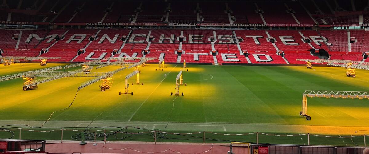 A football stadium with the words "MANCHESTER UNITED" painted on the seats.