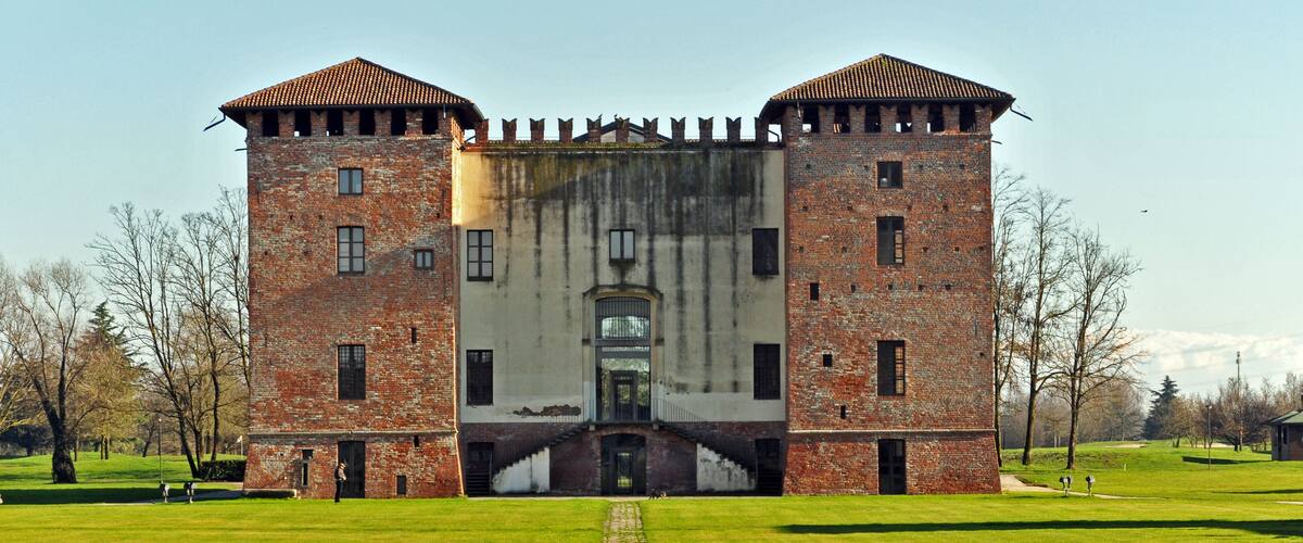 A large brick castle with two towers and a central entrance.