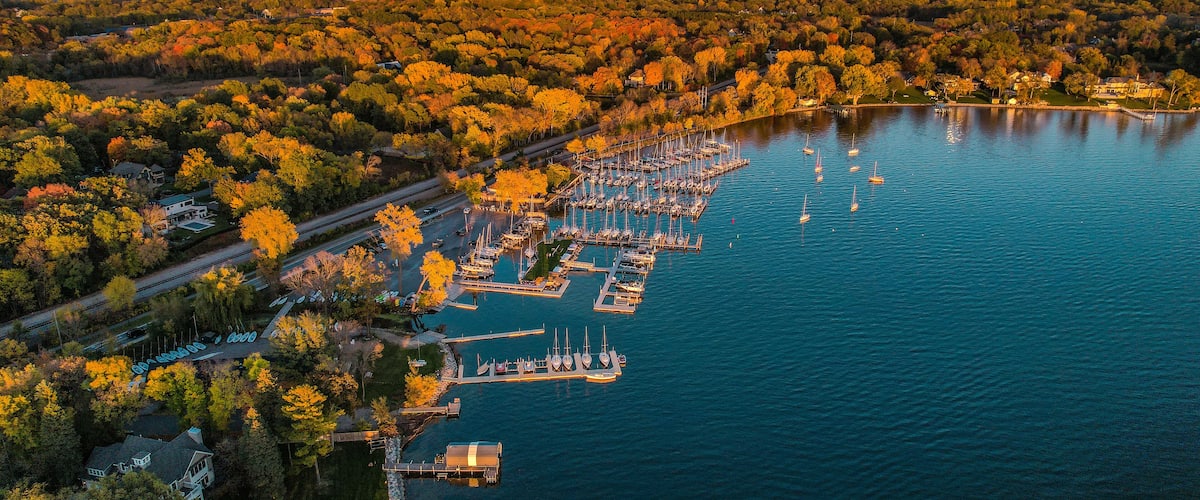 An aerial view of a marina surrounded by autumn foliage.