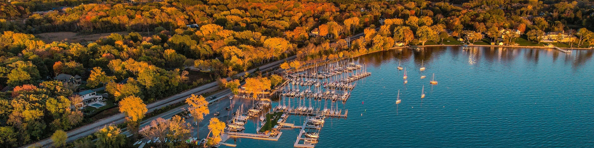An aerial view of a marina surrounded by autumn foliage.
