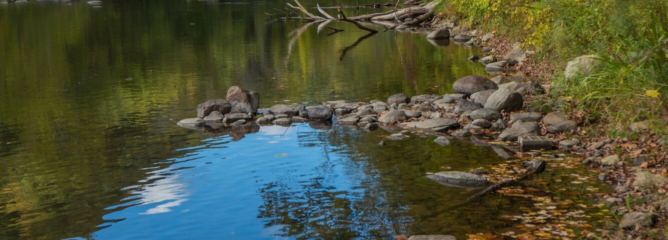 River in Cornwall, New England in early fall showing reflections of deep blue fall sky