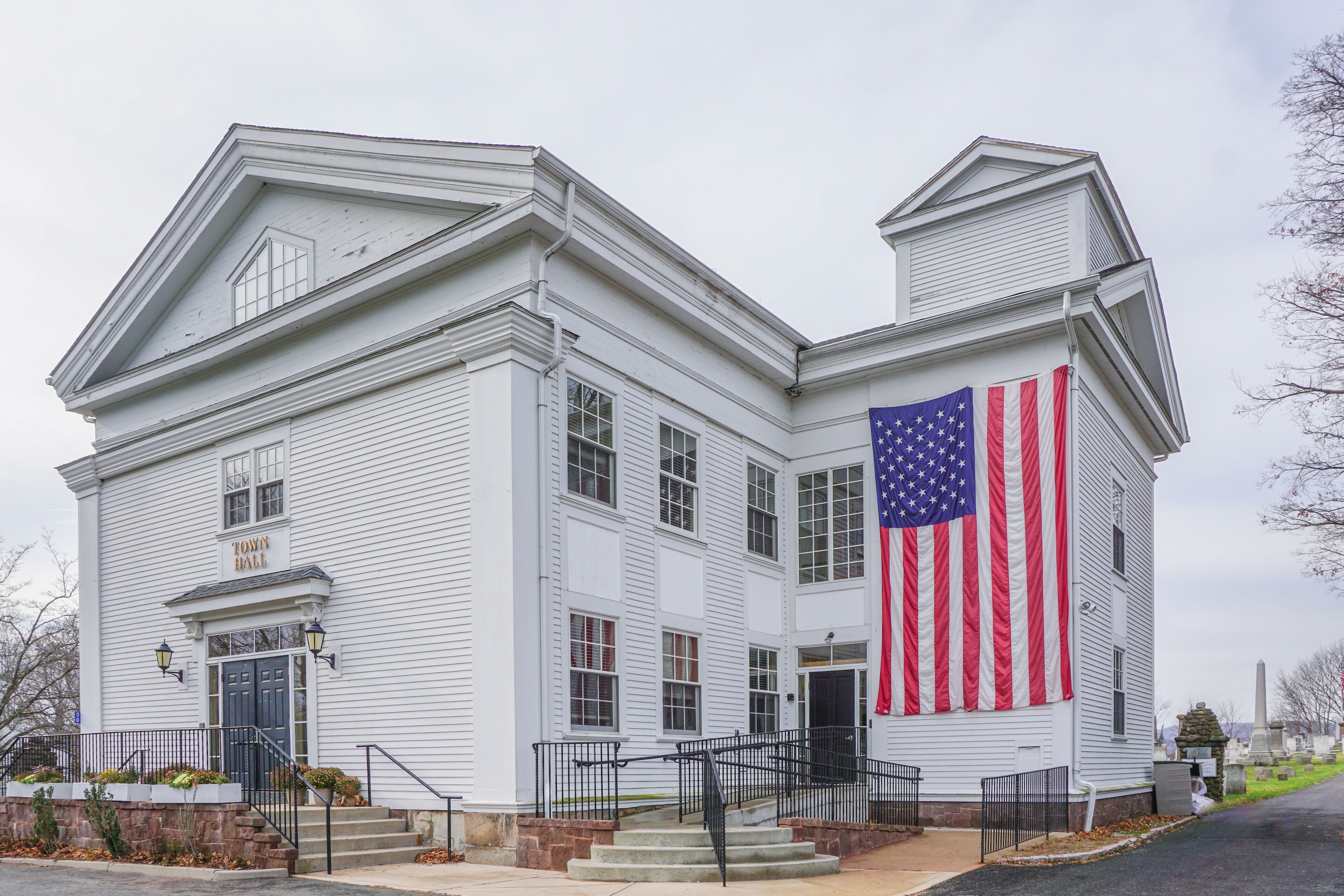 A white building with a large American flag on the side.