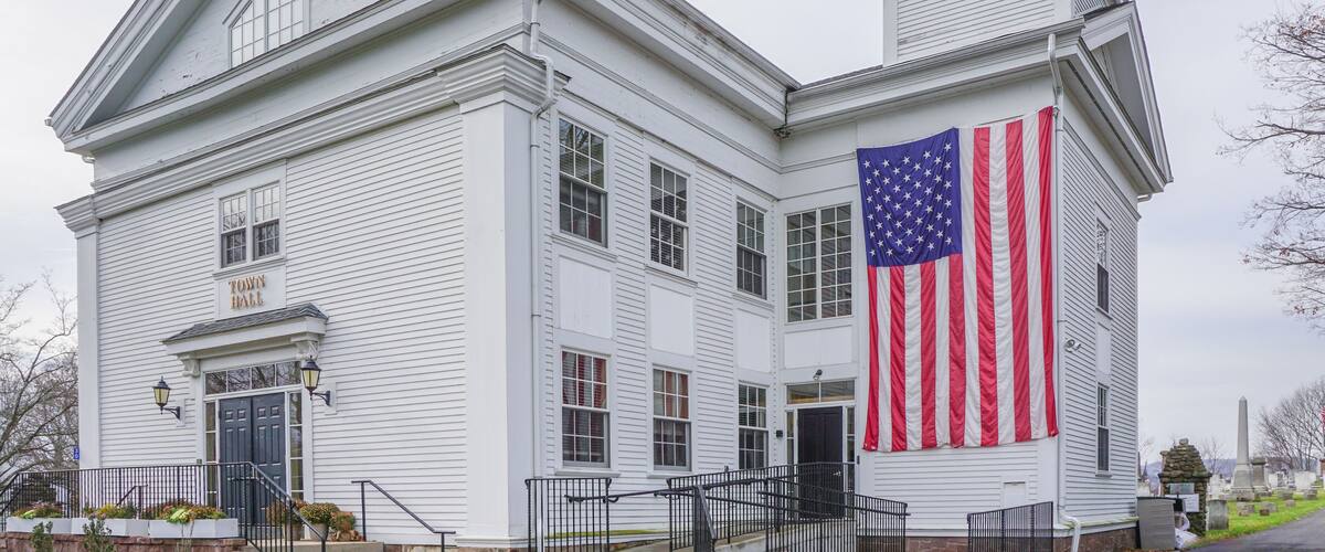 A white building with a large American flag on the side.