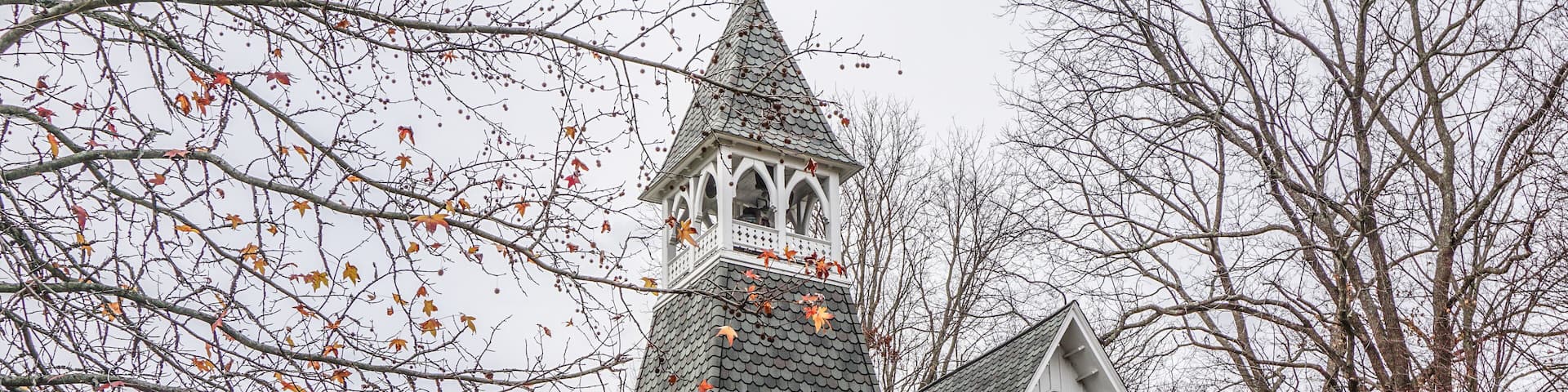 A white church with a steeple and a red door.