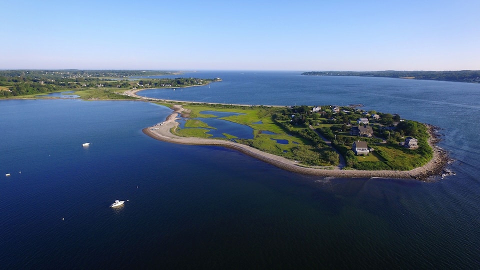 An aerial view of a small island with a dense cluster of houses surrounded by water.
