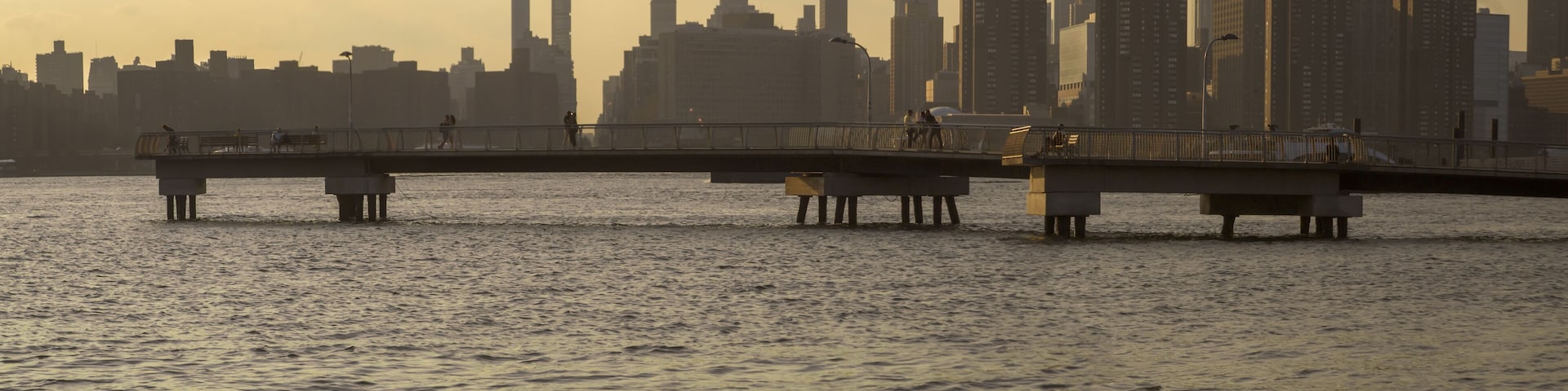 Pier extending out onto the East River, sunset scene from Transmitter Park in Greenpoint, Brooklyn