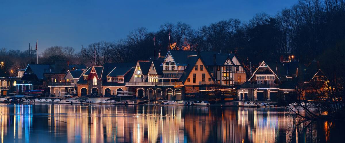 A waterfront town with historic buildings and a calm lake reflecting the lights.