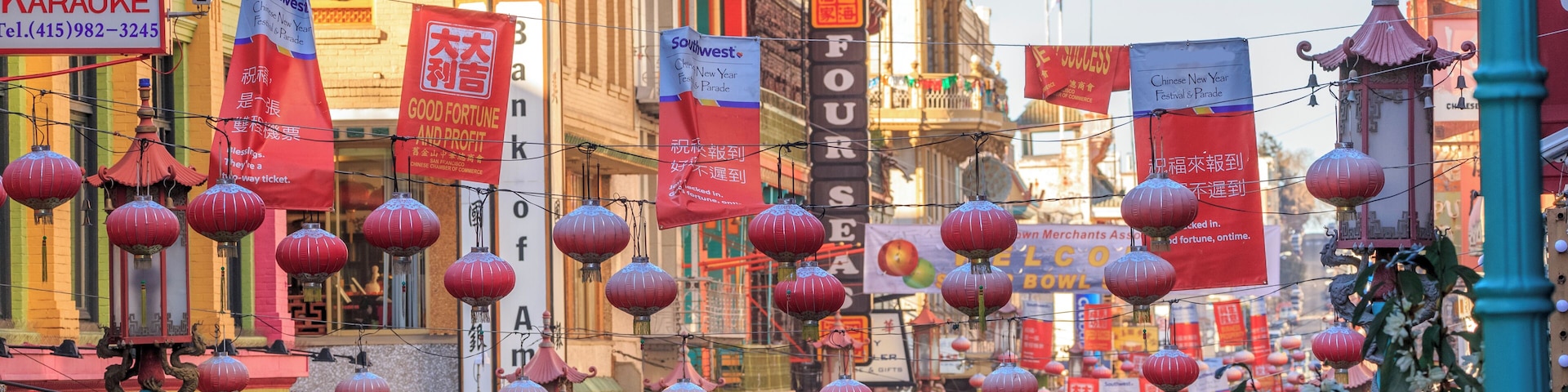View of the main street of the chinatown district, traffic of cars and people in a cloudy day.