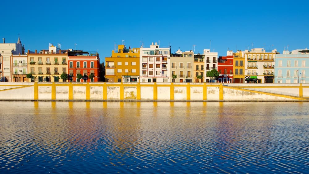 A waterfront with colorful buildings and a yellow bridge.