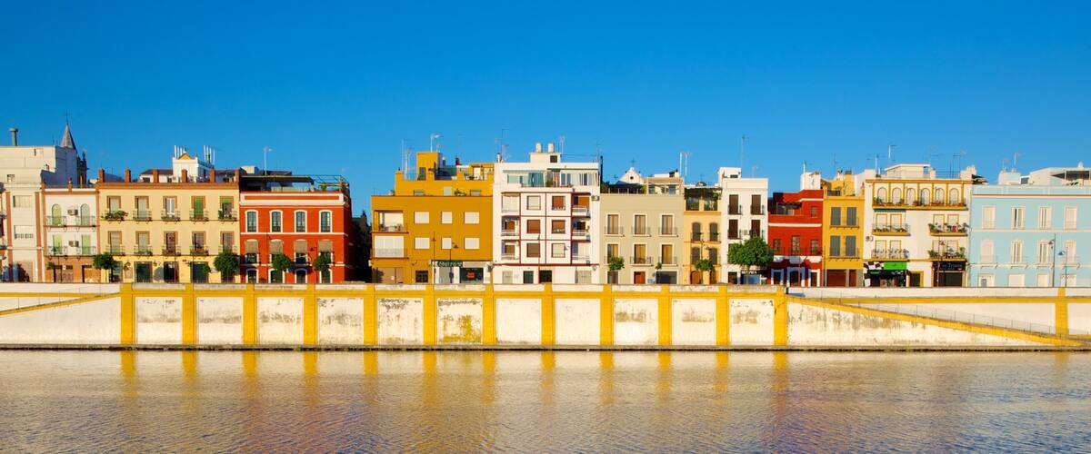 A waterfront with colorful buildings and a yellow bridge.