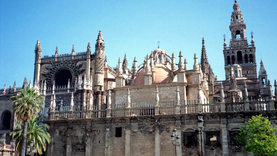 A historic cathedral with intricate Gothic architecture, including spires, a large rose window, and detailed stonework.