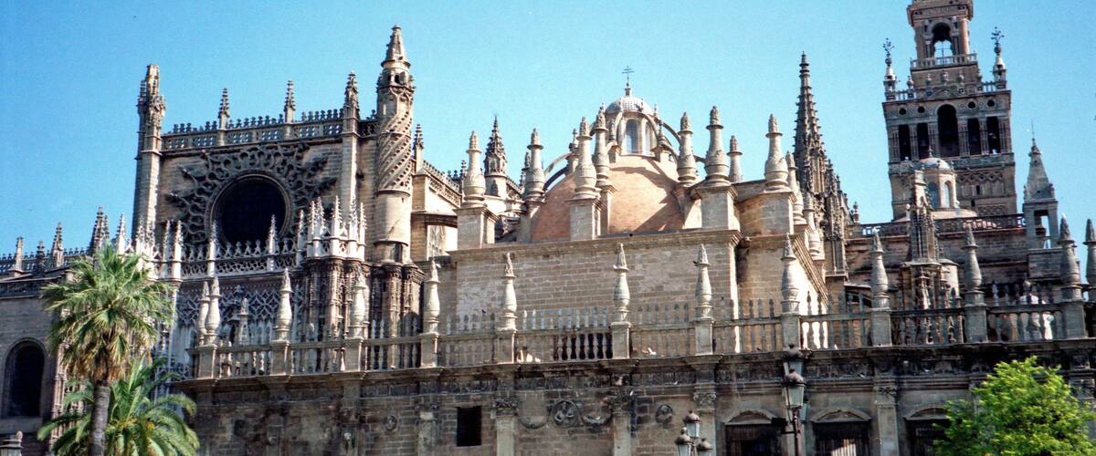 A historic cathedral with intricate Gothic architecture, including spires, a large rose window, and detailed stonework.