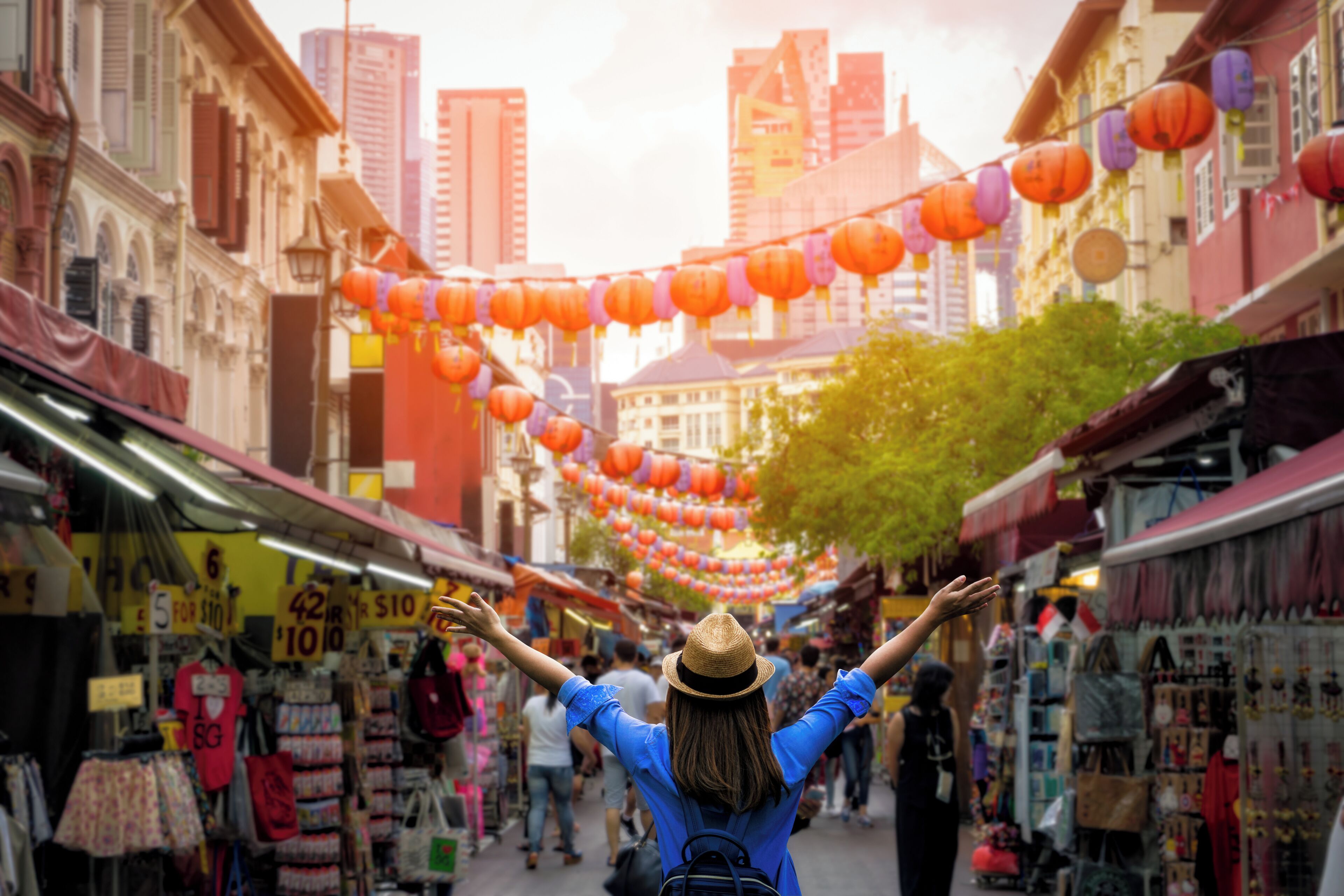 A street market with colorful lanterns and various shops.