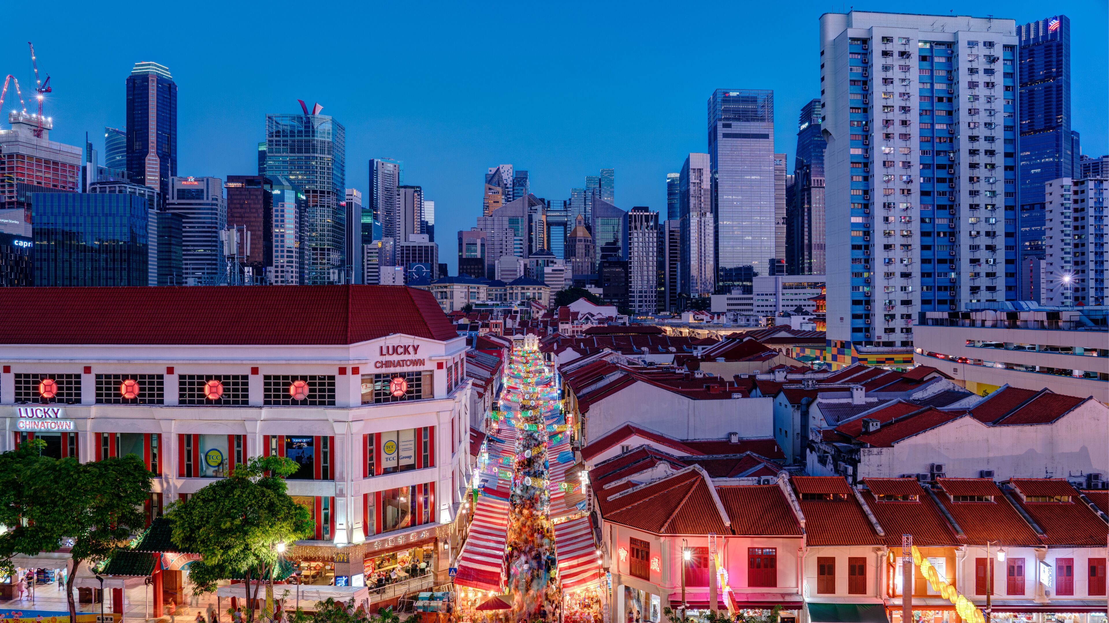 En stadsbild med en framträdande byggnad som är märkt med texten ”Lucky Chinatown” och en traditionell kinesisk lyktuppsättning.