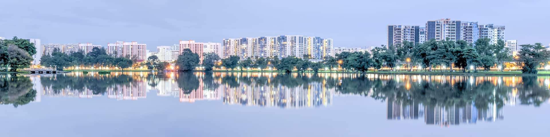 Panorama reflection of new estate HDB housing complex on Jurong Lake neighborhood in Singapore at twilight. Urban concept