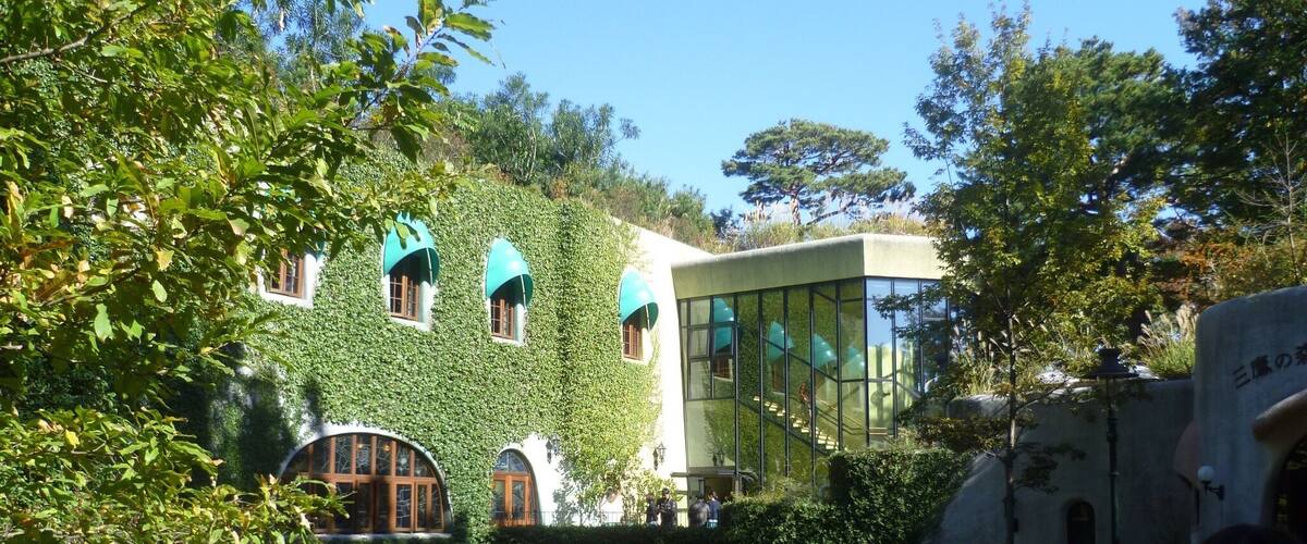 A building covered in ivy with arched windows and a glass facade.