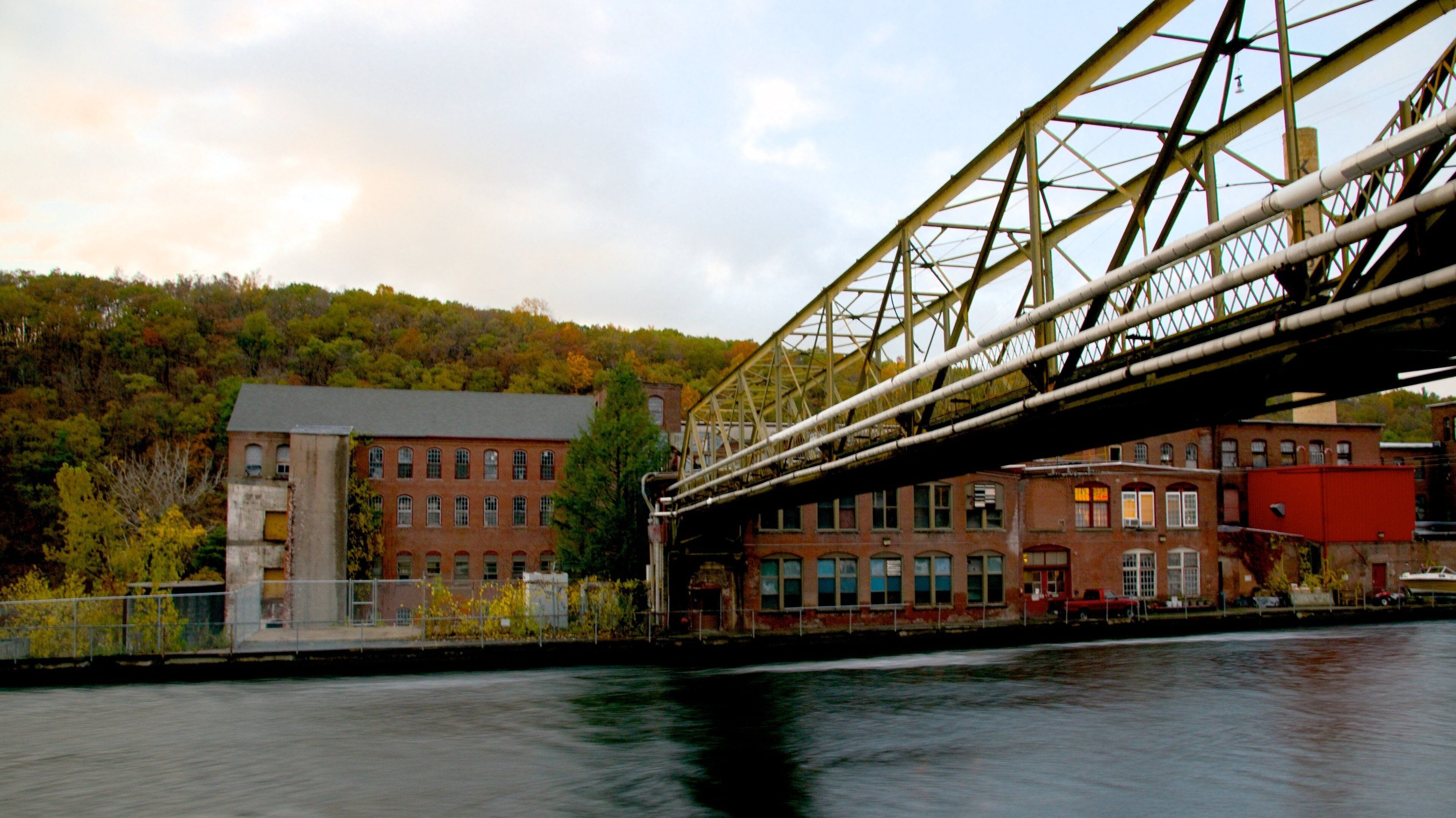A bridge over a river with buildings and trees in the background.