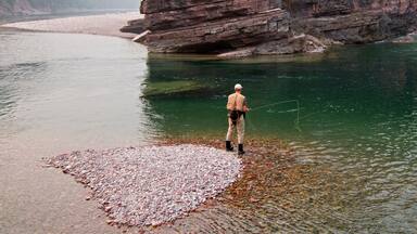 Fly fishing at the confluence of the Flathead and Spotted Bear Rivers in the Bob Marshall wilderness area during the 2017 fall fires in Montana United States