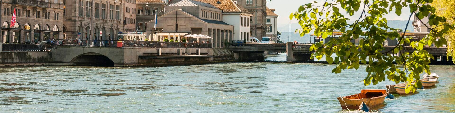 A river with boats, a bridge, and historic buildings with towers.