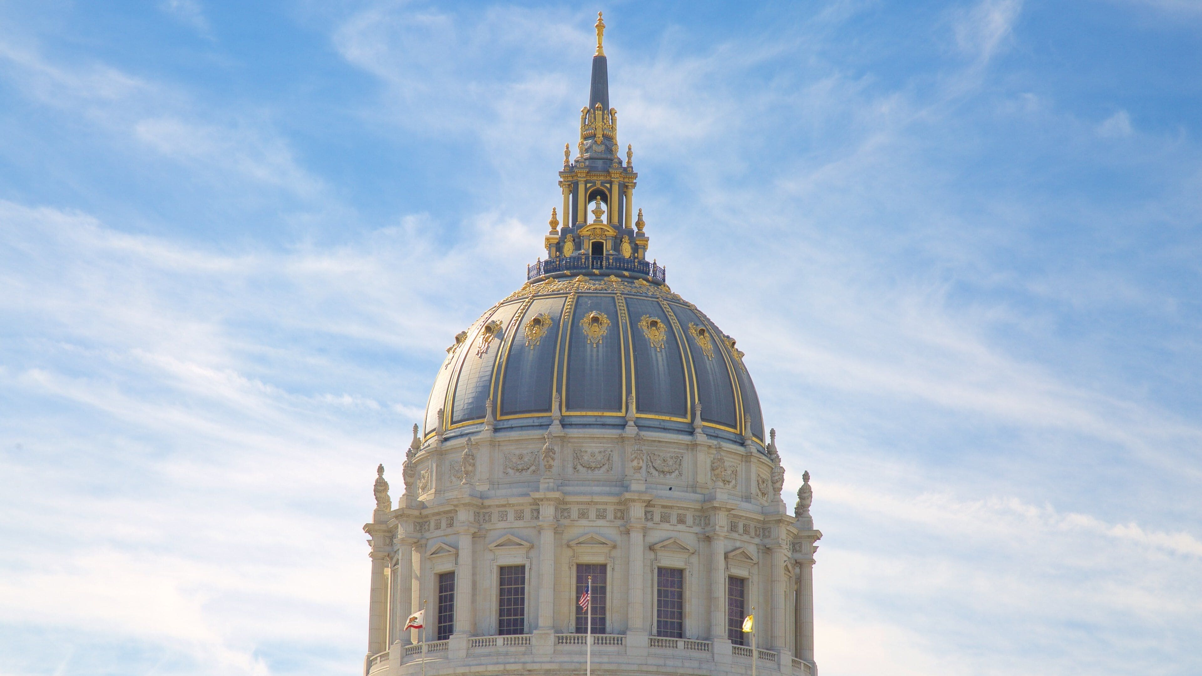 A large domed building with ornate golden details and a flag.