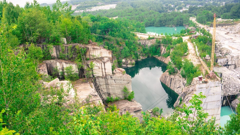 A gorge with a river, rocky cliffs, and a construction crane.