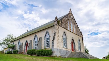 Vintage brick/ concrete wall chapel with red front door and stained glass windows in the countryside. Duncans Methodist Church in Trelawny parish, Jamaica, built in AD 1882.