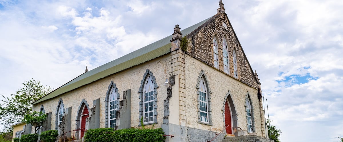 A historic stone church with arched windows and a steeply pitched roof.