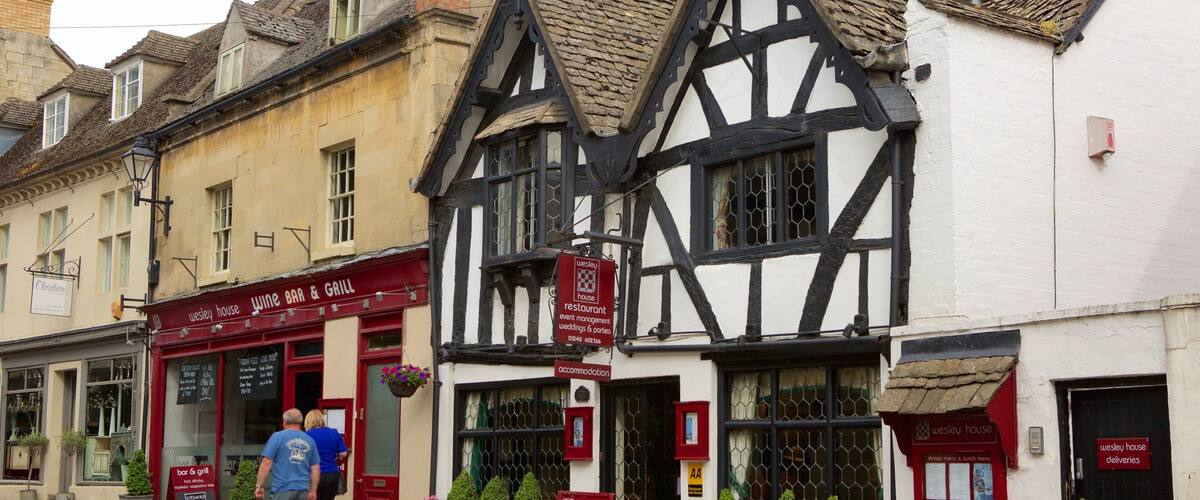 A traditional Tudor-style building with a 'Wesley House' sign, a wine bar, and a restaurant.