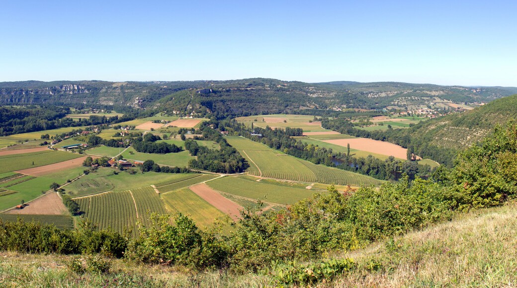 The view over patchwork fields and farms encircled by the River Lot. From Saut de la Mounine viewpoint near Cajarc, Lot, Quercy, France. Stitched panorama.