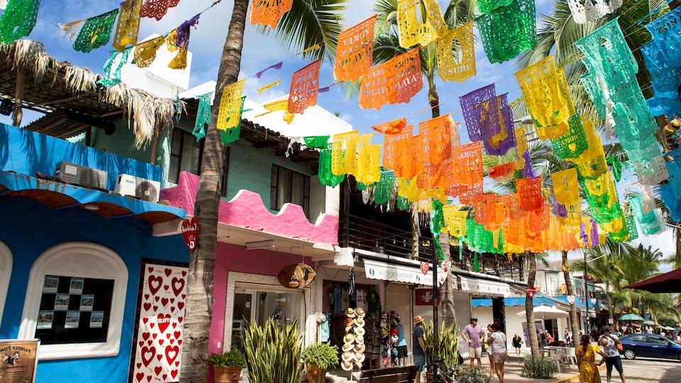 Colorful paper decorations, a blue building, and palm trees.