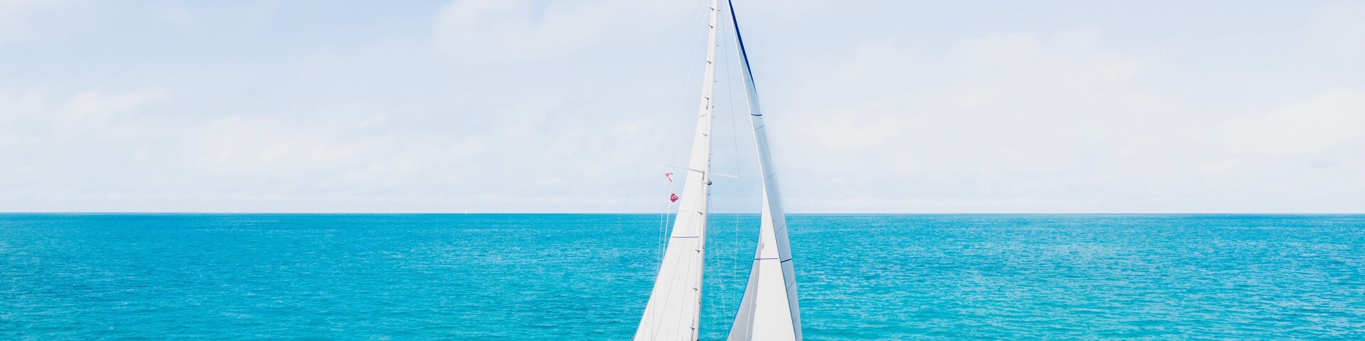 Un velero en aguas turquesas bajo un cielo despejado.