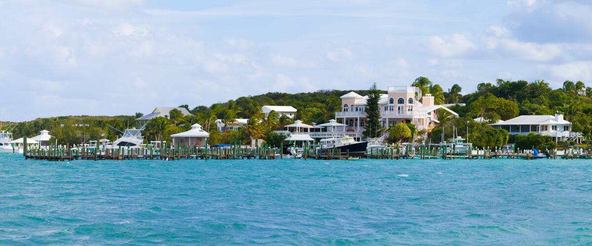 A coastal area with a marina, waterfront buildings, and lush greenery.