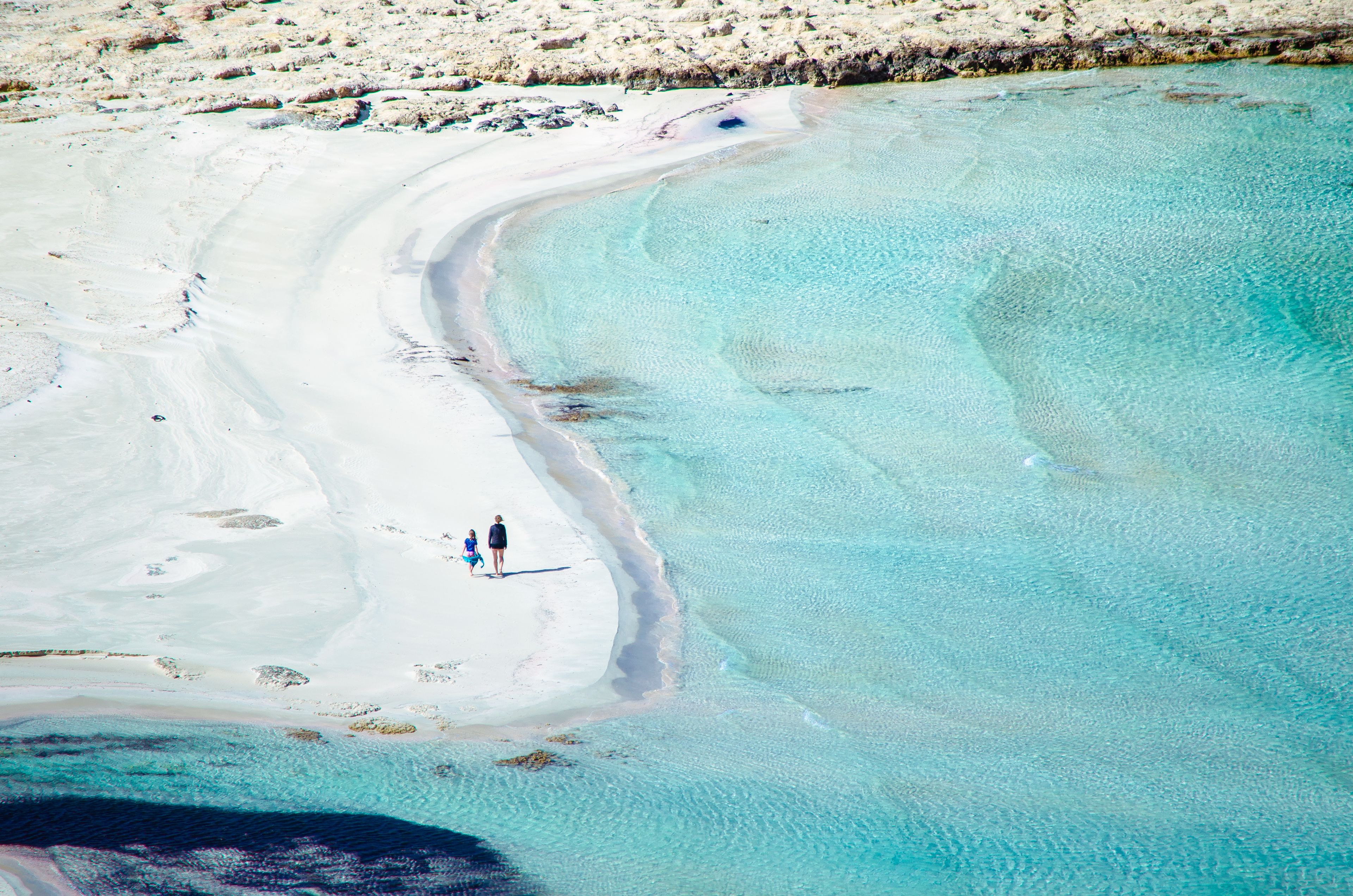 View of the amazing beach of Balos, with a family playing on the tropical sandy beach with turquoise waters, Crete, Greece