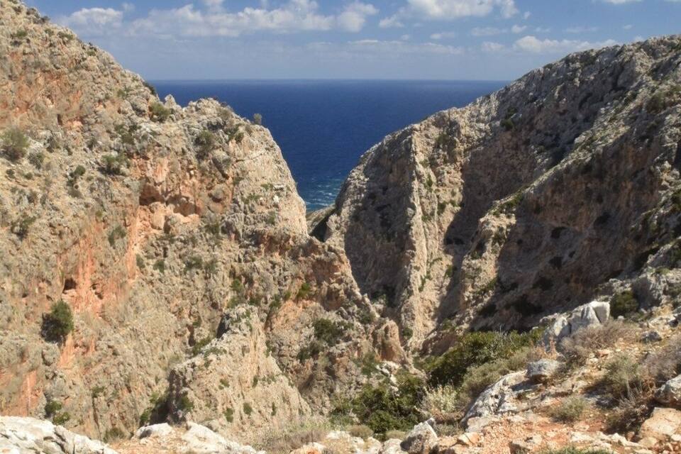 Paesaggio montuoso e impervio, con roccia a vista e vegetazione rada.