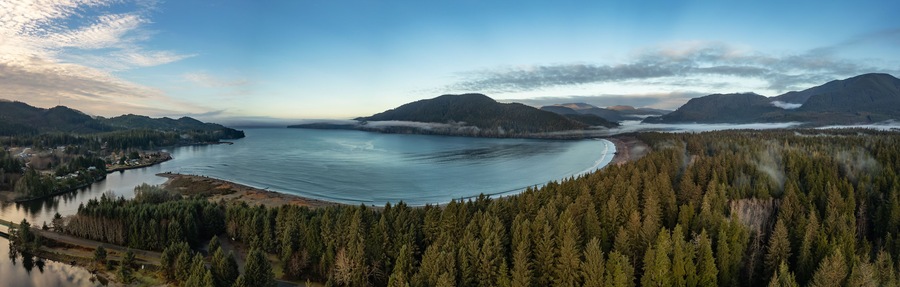 Un lago extenso rodeado de bosques frondosos y montañas.