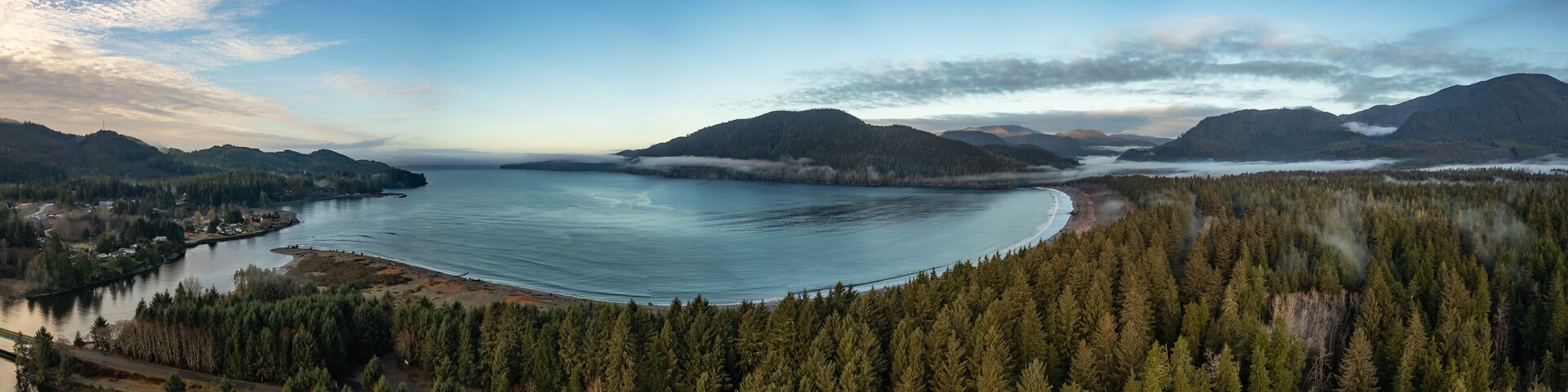 Un lago extenso rodeado de bosques frondosos y montañas.