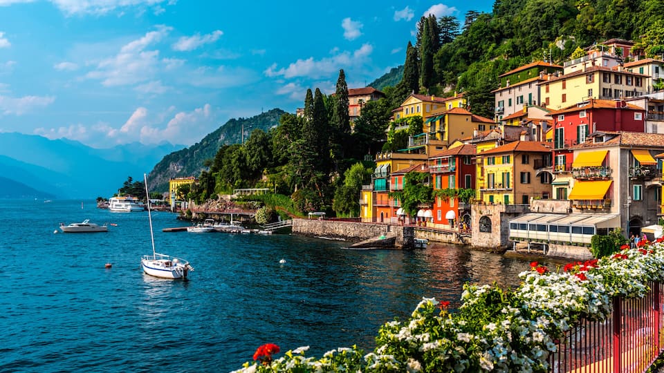 A coastal town with colorful buildings, a calm sea, and boats.