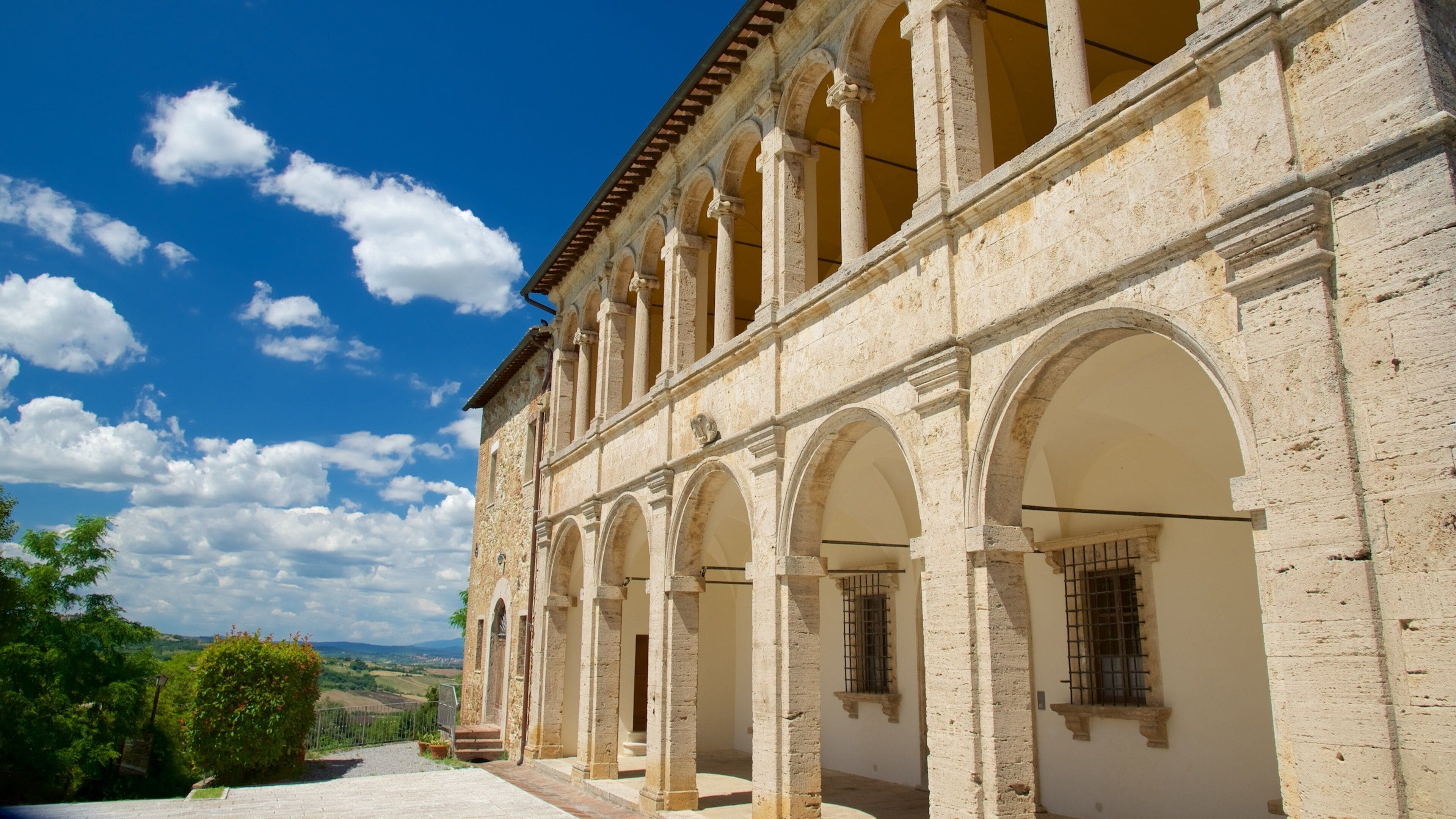 A historic building with arched windows and columns, set against a clear blue sky.