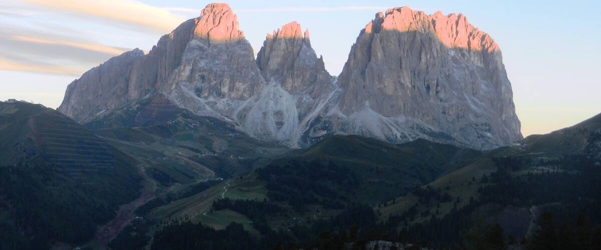 Una serralada amb dues cimes destacades, una vall amb camps en terrasses i un cel serè.