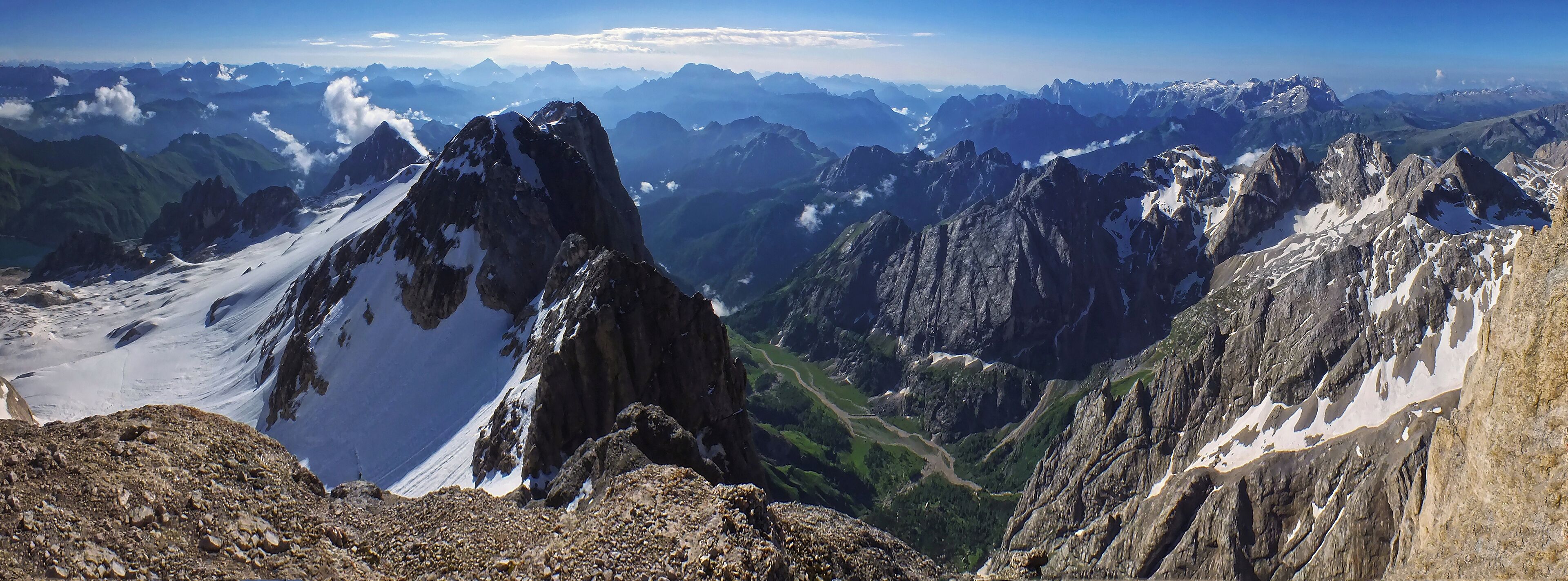 A mountain range with snow-capped peaks and a valley below.