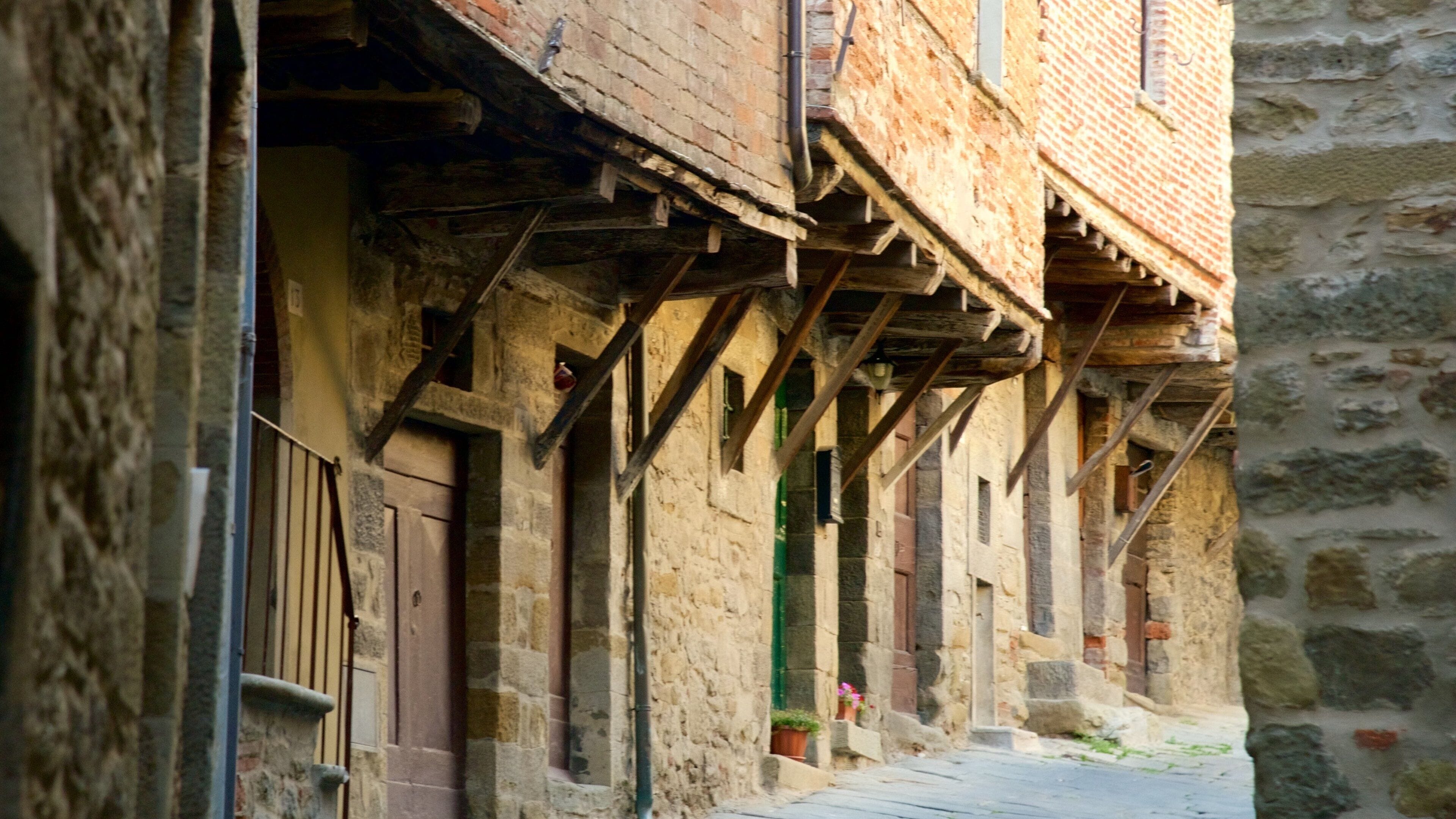 Une rue étroite bordée d’anciens bâtiments en pierre, de poutres en bois et d’un chemin pavé.