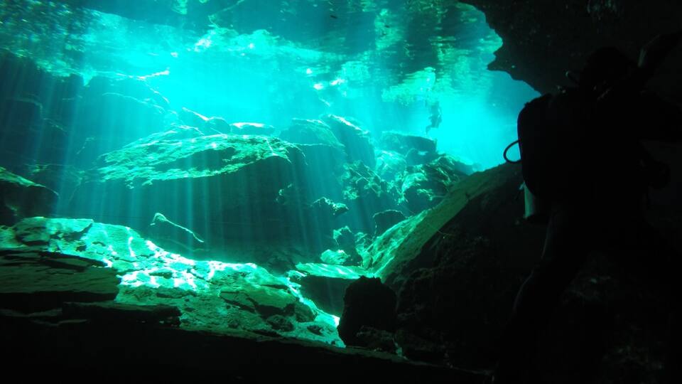 An underwater cave with rock formations and water.