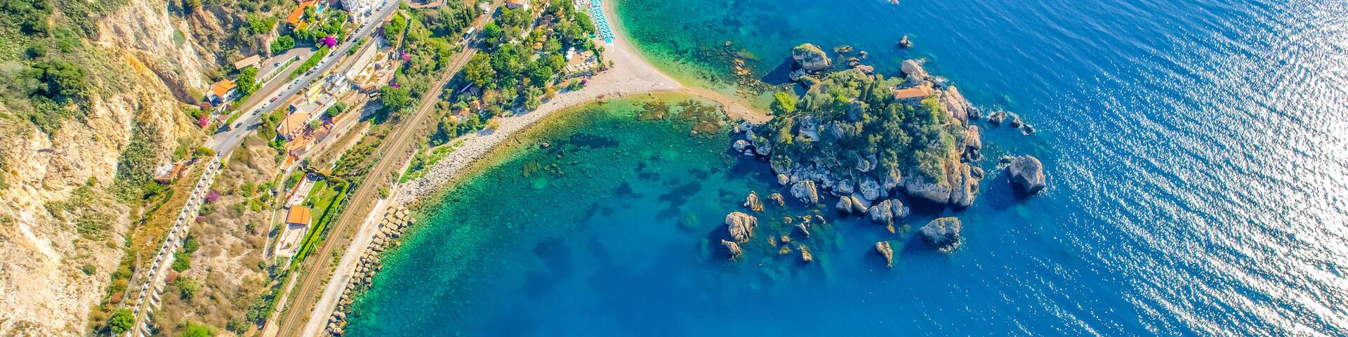 Aerial view of the Ancient theater of Taormina with Mount Etna in the background, Sicily, Italy. Isola Bella island