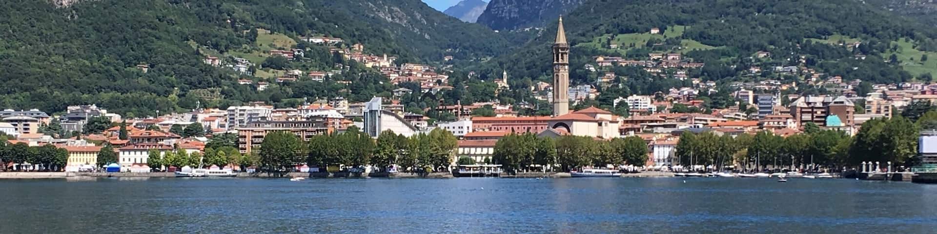 A lake with a town and mountains in the background.