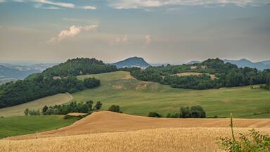Colline dolci, una montagna in lontananza e un piccolo edificio su una collina.