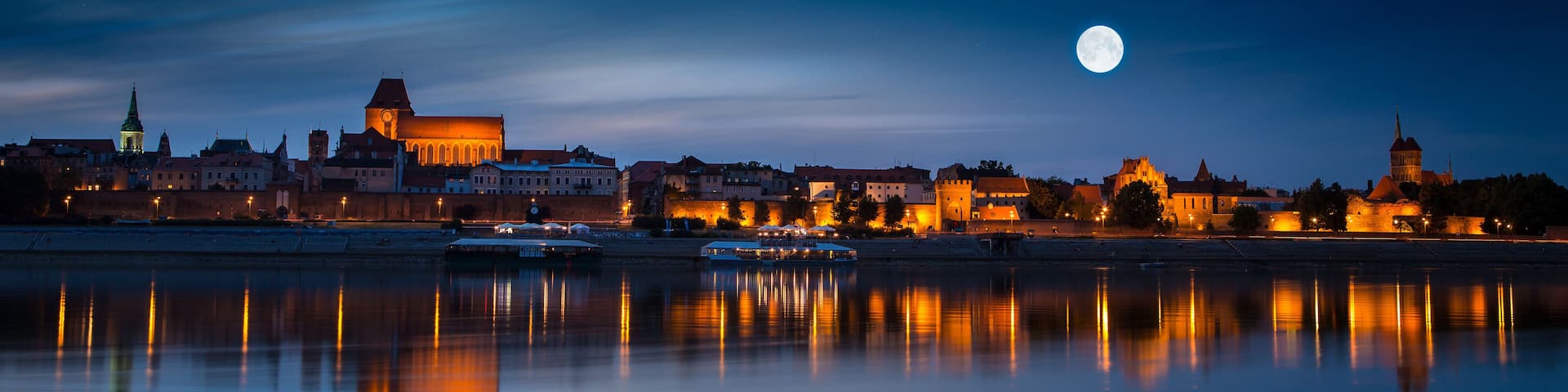 Old town reflected in river at sunset. Torun, Poland