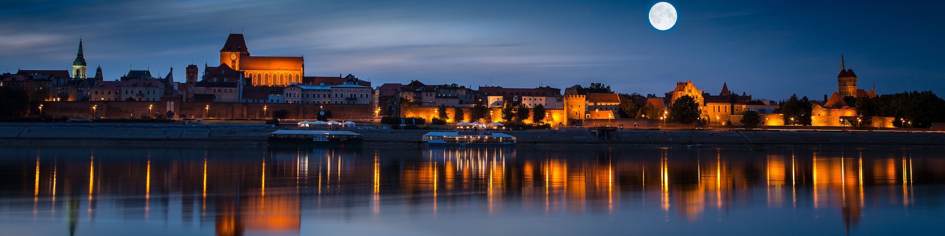 Old town reflected in river at sunset. Torun, Poland